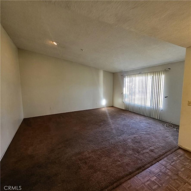 empty room with carpet floors and a textured ceiling