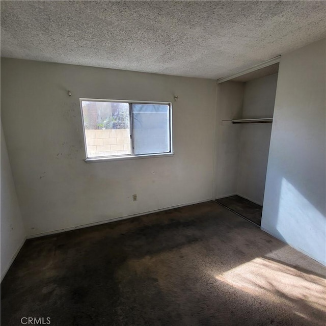 carpeted spare room featuring a textured ceiling