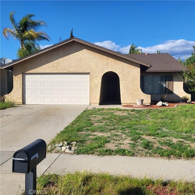 ranch-style home with a garage, driveway, a front lawn, and stucco siding