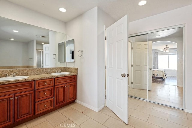 ensuite bathroom with a ceiling fan, a sink, ensuite bath, recessed lighting, and double vanity