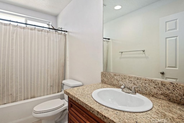 full bathroom featuring vanity, toilet, shower / bathtub combination with curtain, and a textured ceiling