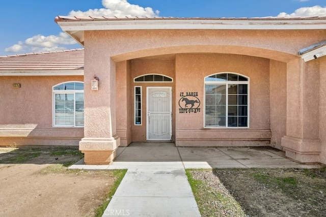 doorway to property featuring stucco siding