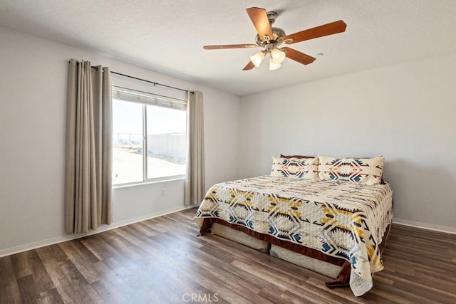 bedroom featuring ceiling fan, baseboards, a textured ceiling, and wood finished floors