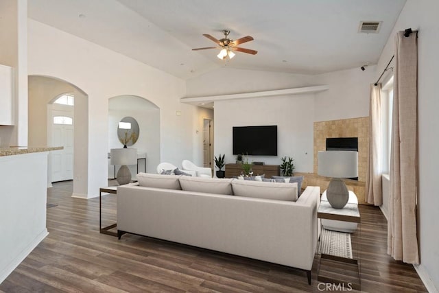 living room featuring visible vents, ceiling fan, lofted ceiling, arched walkways, and dark wood-style flooring