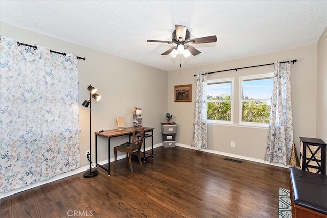 home office with a textured ceiling, baseboards, and wood finished floors