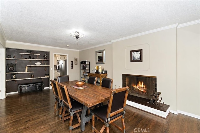 dining area with a textured ceiling, a fireplace, ornamental molding, and wood finished floors