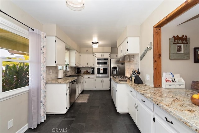 kitchen featuring appliances with stainless steel finishes, white cabinetry, and tasteful backsplash