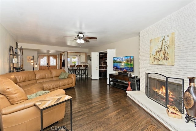 living area featuring ceiling fan, french doors, a fireplace, and wood finished floors