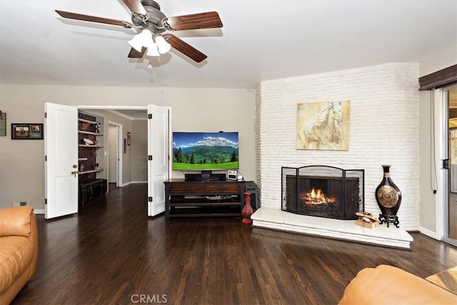 living room featuring a fireplace, wood finished floors, a ceiling fan, and baseboards