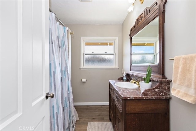 bathroom featuring a shower with shower curtain, vanity, baseboards, and wood finished floors