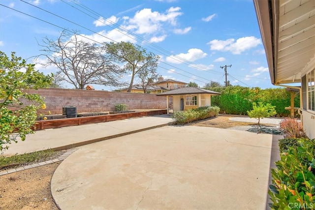 view of patio / terrace with an outdoor structure and a fenced backyard