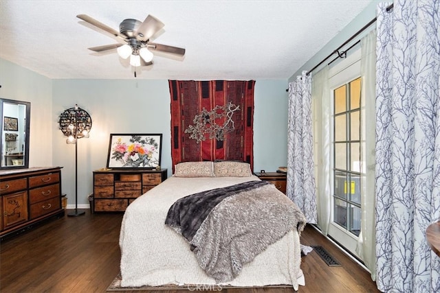 bedroom with a textured ceiling, wood finished floors, visible vents, and a ceiling fan