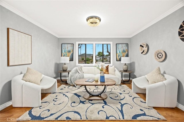 living area featuring ornamental molding, wood finished floors, and baseboards