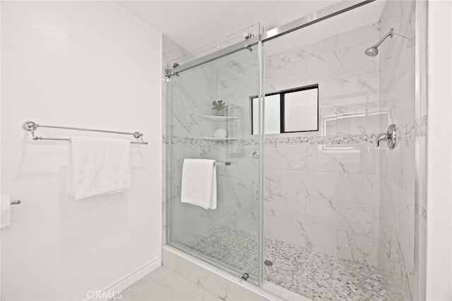 bathroom with baseboards and a marble finish shower