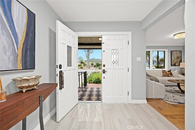 foyer with baseboards and light wood-style floors