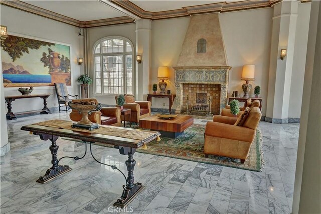 sitting room featuring ornamental molding, marble finish floor, and decorative columns