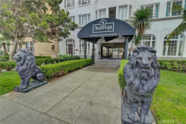 entrance to property featuring a yard and stucco siding