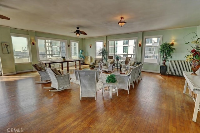 sunroom / solarium featuring radiator and ceiling fan