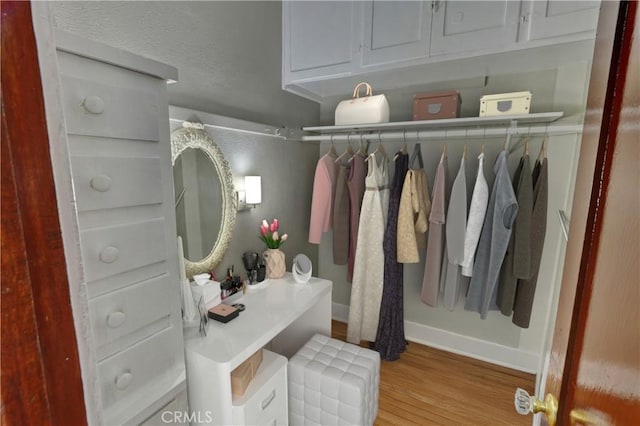 walk in closet with wood finished floors