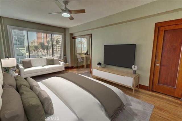 bedroom with a ceiling fan, baseboards, and wood finished floors