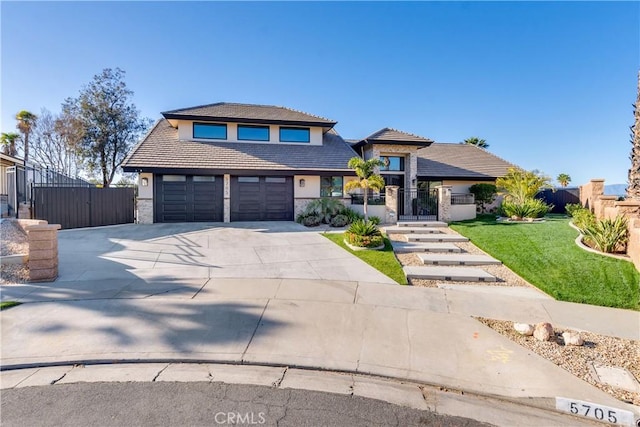 view of front of house with fence, concrete driveway, stone siding, a gate, and stucco siding