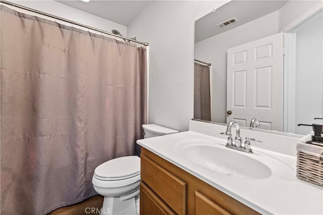 bathroom featuring toilet, vanity, visible vents, and a shower with curtain