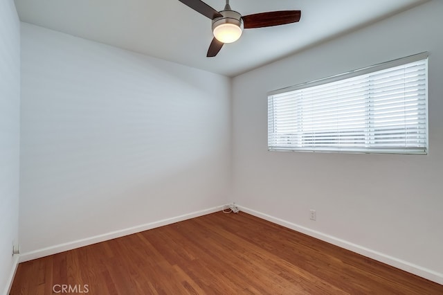 spare room with ceiling fan, baseboards, and wood finished floors