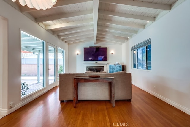 unfurnished living room with vaulted ceiling with beams, wooden ceiling, a fireplace, baseboards, and light wood-style floors