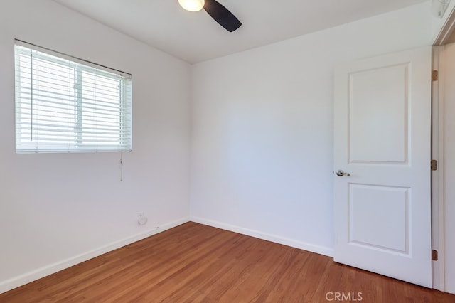 empty room with baseboards, ceiling fan, and light wood-style floors