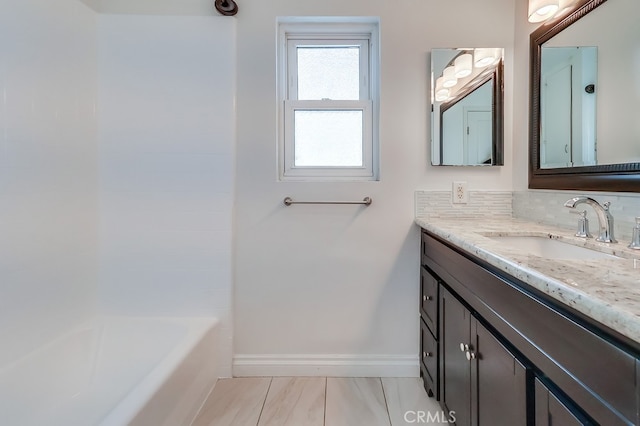 full bathroom featuring decorative backsplash, vanity, and baseboards