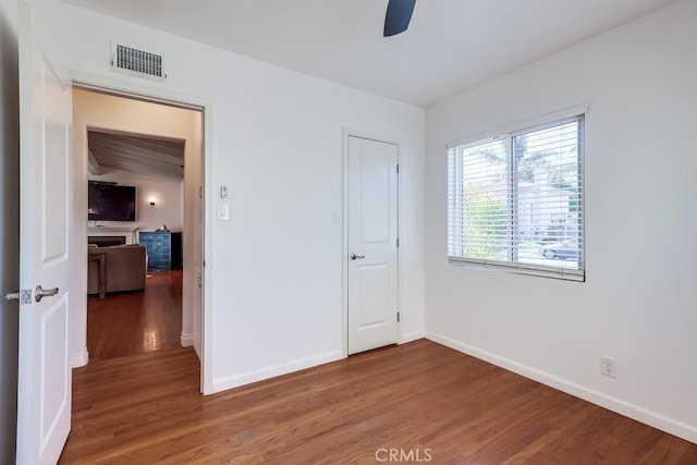 unfurnished bedroom with ceiling fan, wood finished floors, visible vents, and baseboards