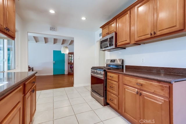 kitchen with light tile patterned floors, recessed lighting, visible vents, appliances with stainless steel finishes, and baseboards