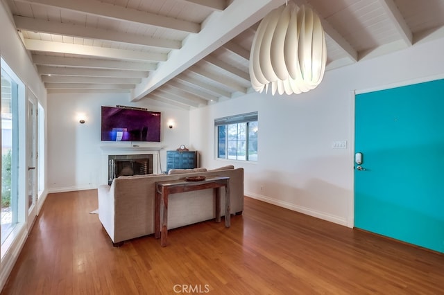 living area with baseboards, wooden ceiling, light wood-style flooring, vaulted ceiling with beams, and a fireplace