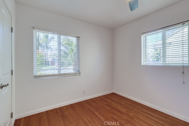 empty room featuring a ceiling fan, baseboards, and wood finished floors