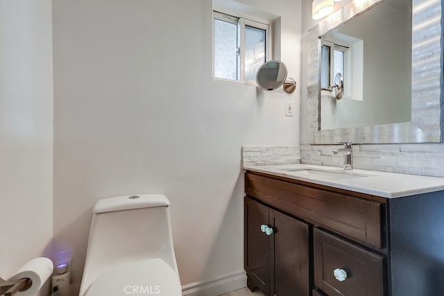 bathroom featuring toilet, decorative backsplash, and vanity