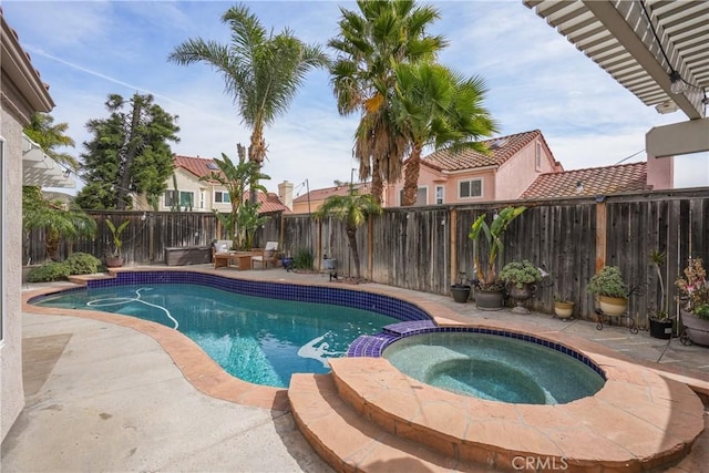 view of swimming pool featuring a pool with connected hot tub, a fenced backyard, and a patio