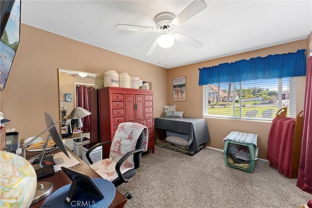 carpeted office space with a ceiling fan