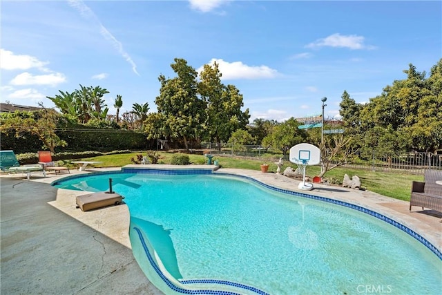 outdoor pool featuring fence and a patio