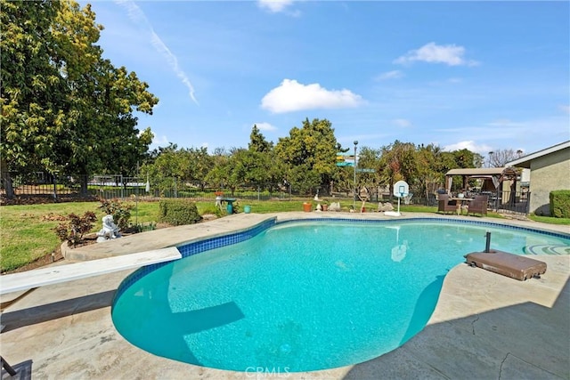 pool with a patio area and fence