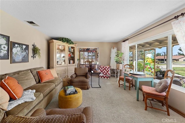 living area with light carpet, a textured ceiling, and visible vents