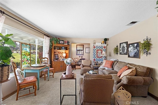 living room featuring light colored carpet, visible vents, a textured ceiling, and baseboards