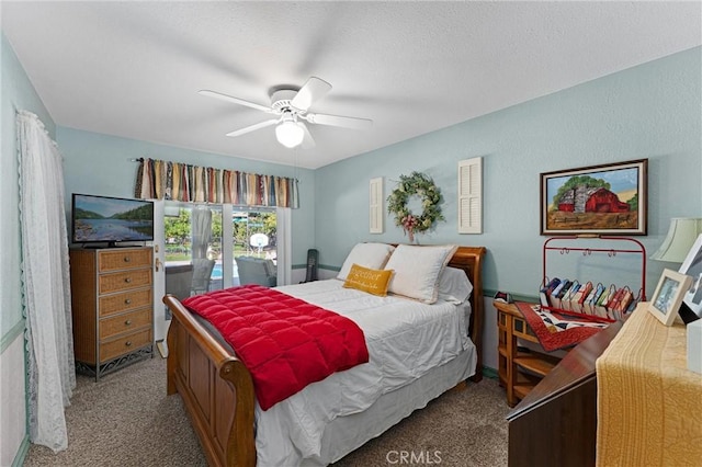 carpeted bedroom with ceiling fan and a textured ceiling