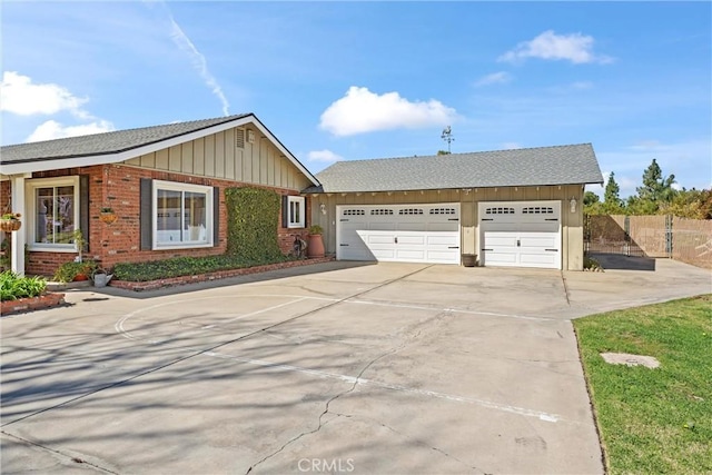 view of front of home with brick siding, a shingled roof, board and batten siding, fence, and driveway