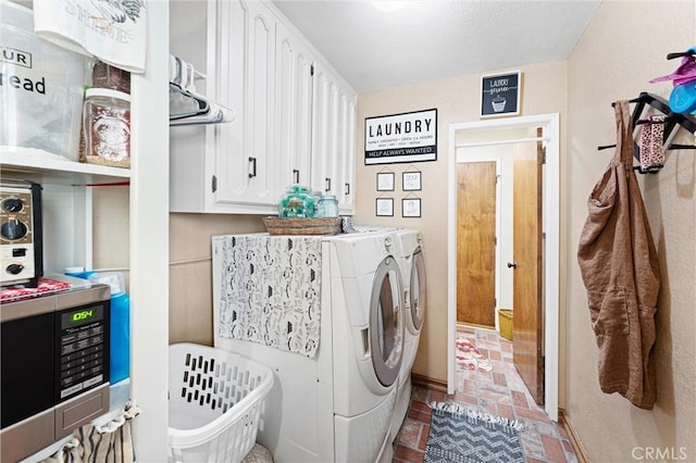 clothes washing area with brick floor, laundry area, and washing machine and clothes dryer