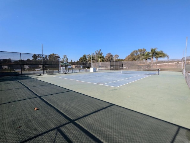 view of tennis court featuring fence