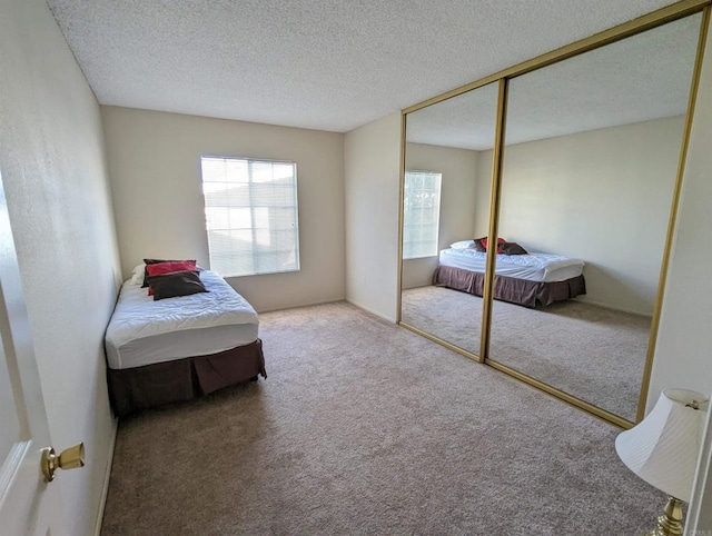 carpeted bedroom with a closet and a textured ceiling