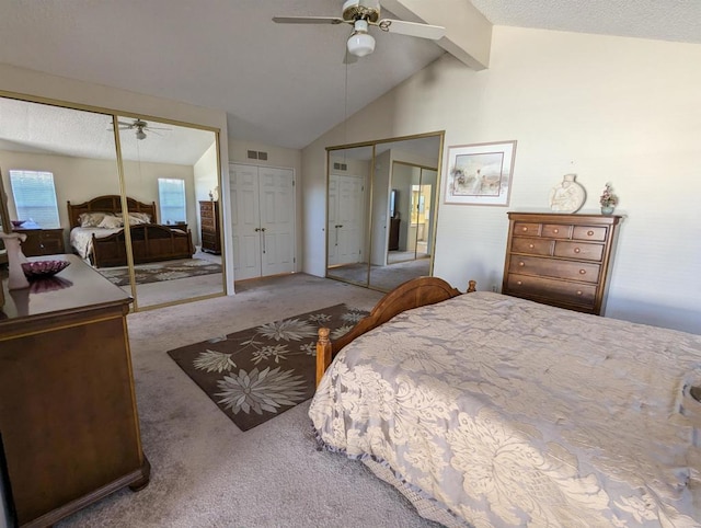 bedroom featuring lofted ceiling with beams, ceiling fan, carpet floors, visible vents, and multiple closets