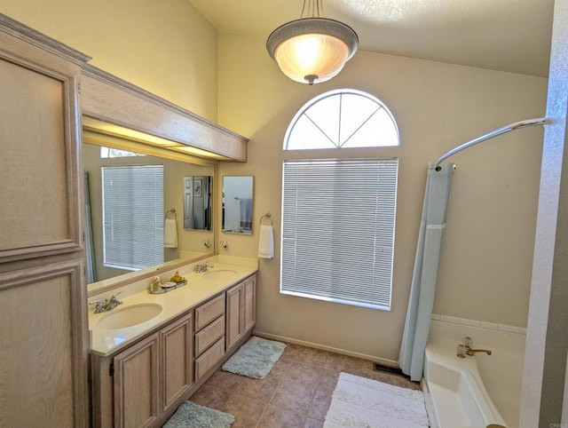 bathroom featuring double vanity, tile patterned flooring, a sink, and a bathing tub