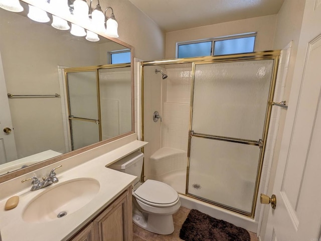 bathroom with tile patterned floors, a shower stall, toilet, and vanity