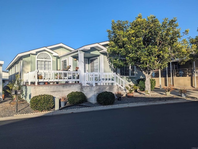 view of front of house with a porch and fence